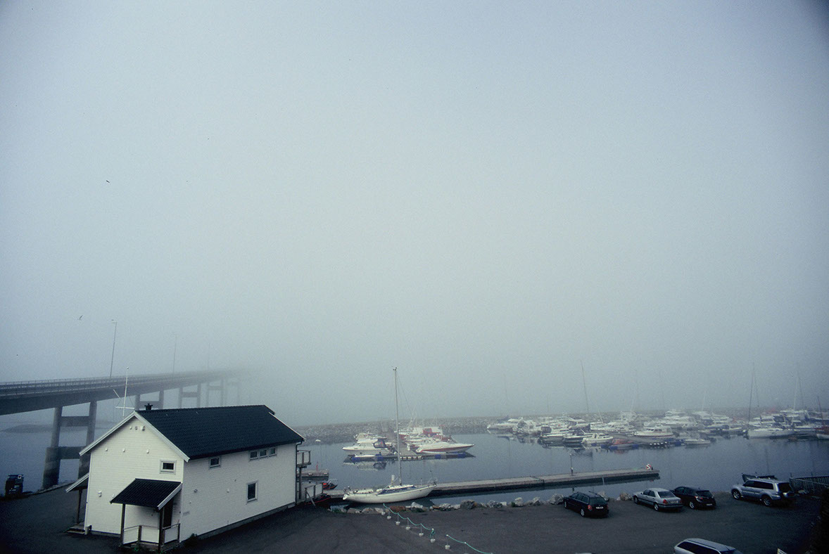 Photographie de rue montrant un matelas et quelques affaires appartenant à un SDF à Lyon, avec en perspective 2 hommes de dos discutant