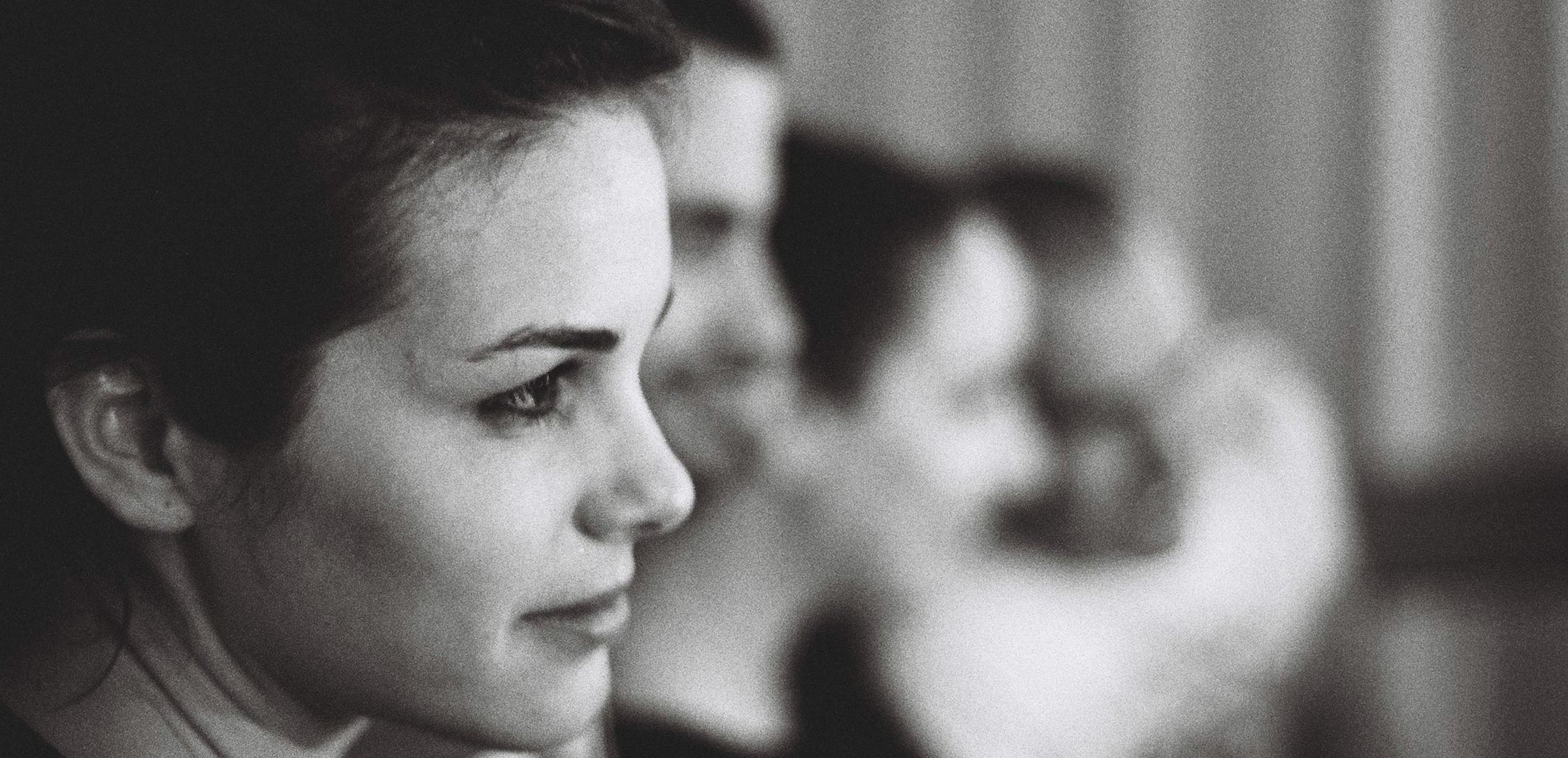 Portrait de profil d'une fille brune, avec en perspective d'autres personnes de profil qui apparissent floues du fait de la profondeur de champ
