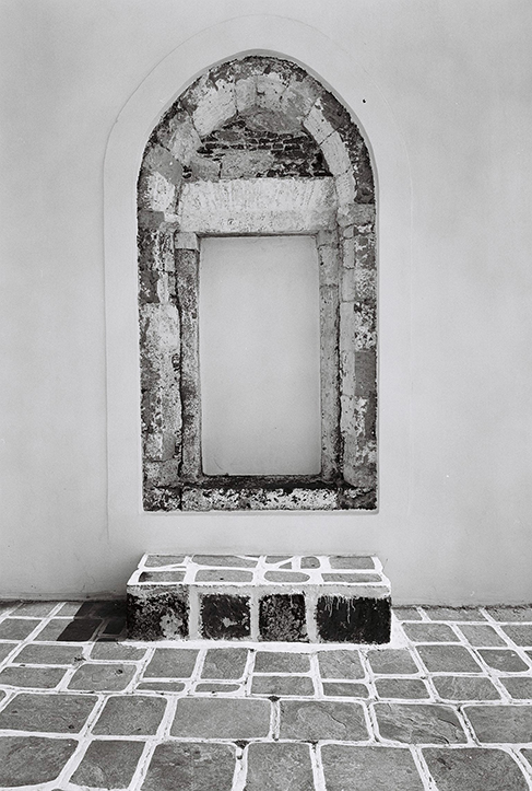 Photographie de rue montrant un matelas et quelques affaires appartenant à un SDF à Lyon, avec en perspective 2 hommes de dos discutant