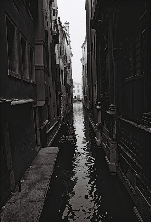 Photographie de rue montrant un matelas et quelques affaires appartenant à un SDF à Lyon, avec en perspective 2 hommes de dos discutant