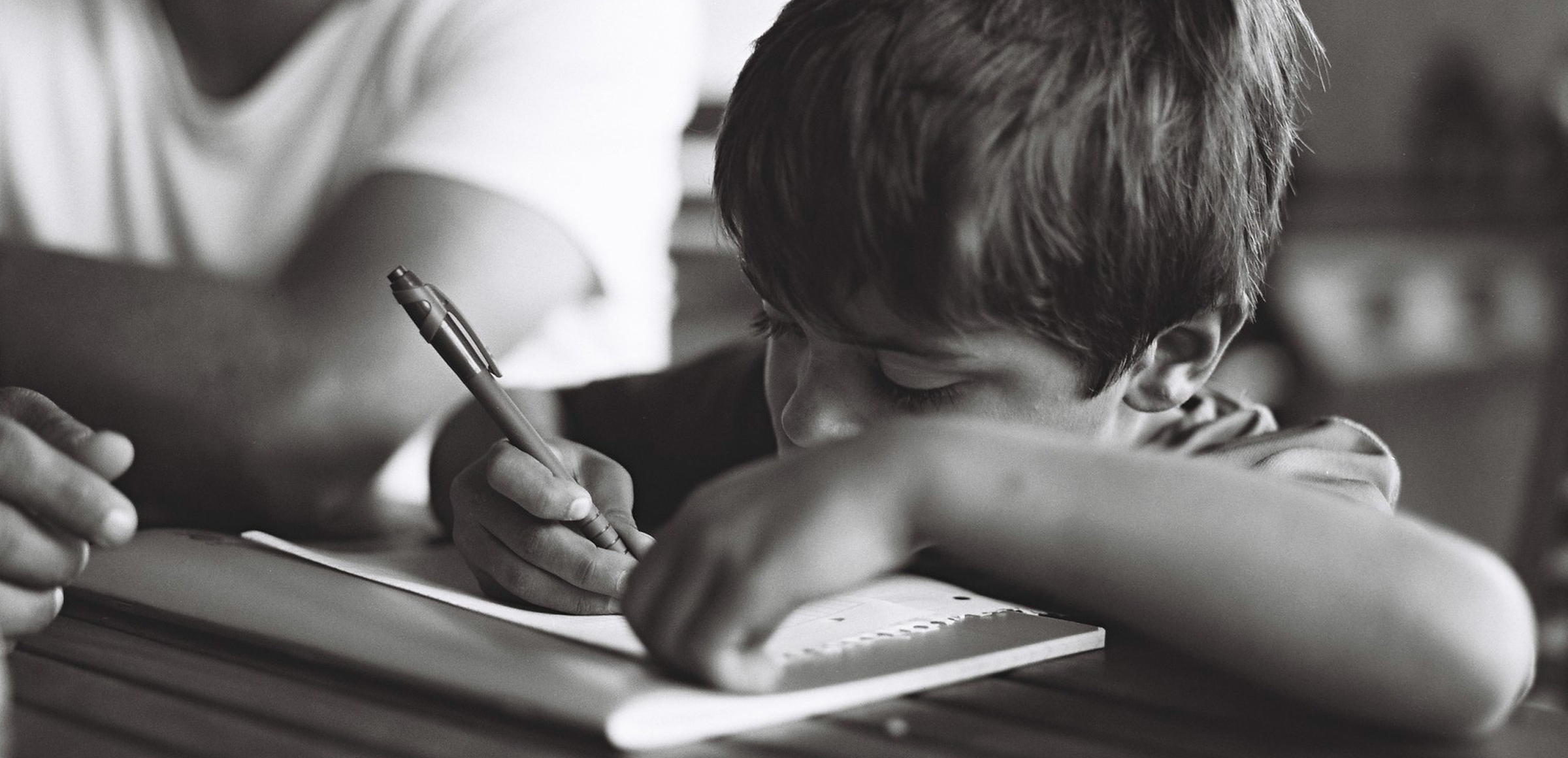 Un portrait d'un garçon faisant ses devoirs aux côtés de son père